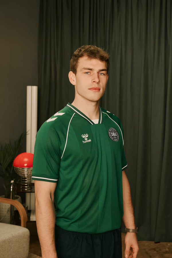 Man wearing a green DUB jersey with logos in an indoor setting